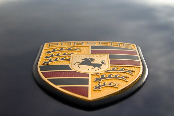 Porsche-Emblem auf grauem Hintergrund hautnah