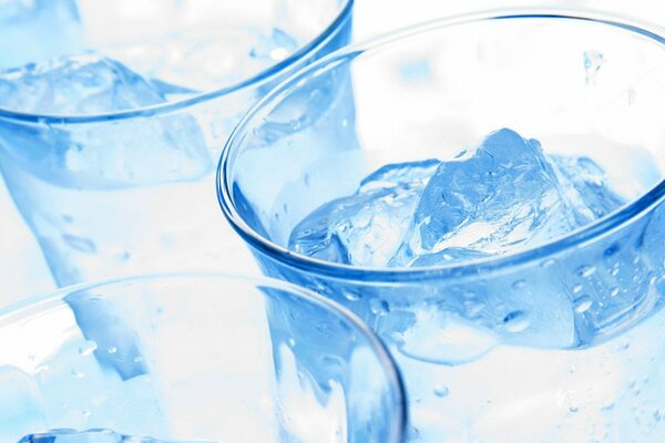 Trois verres en verre transparent avec liquide clair et glace dans des tons bleus