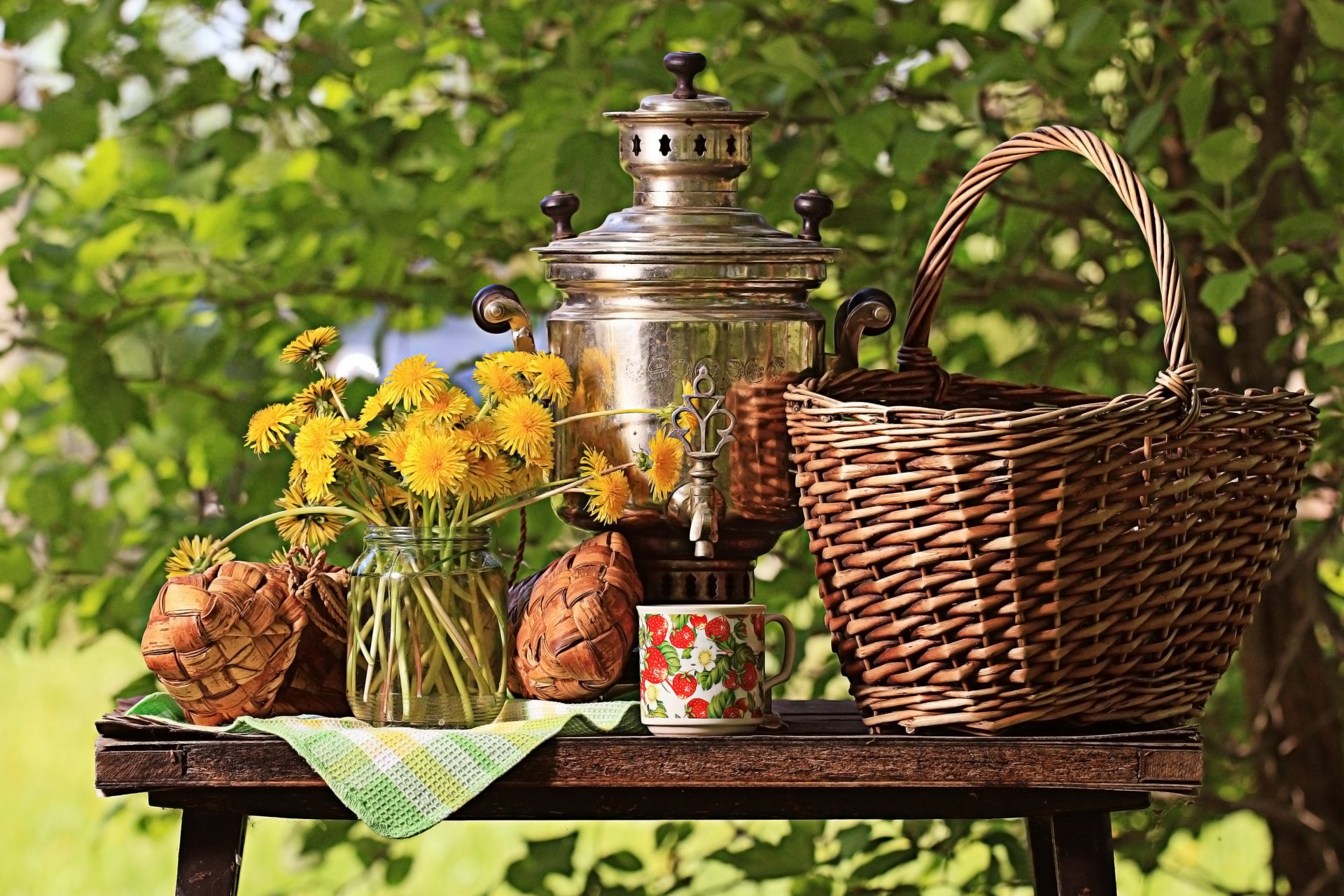 nature morte table panier samovar tasse nappe pot fleurs bouquet pissenlits jaune nature verdure buissons soleil bokeh