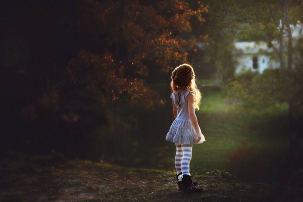 A little girl against the background of nature looking into the distance