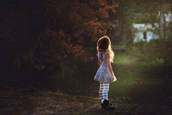 Una niña en el fondo de la naturaleza mirando a la distancia