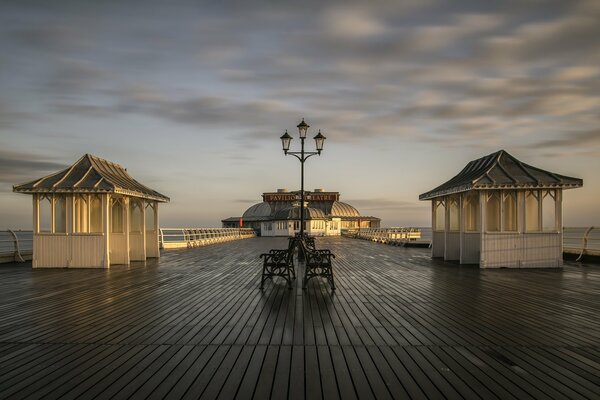 Muelle mojado después de la lluvia en el fondo del cielo elegante