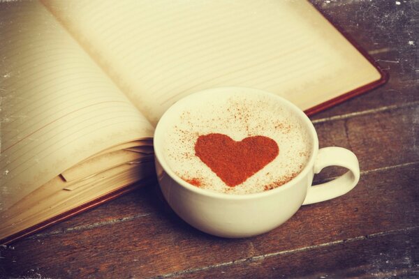 Filiżanka kawy z wzorem serca i pamiętnikiem