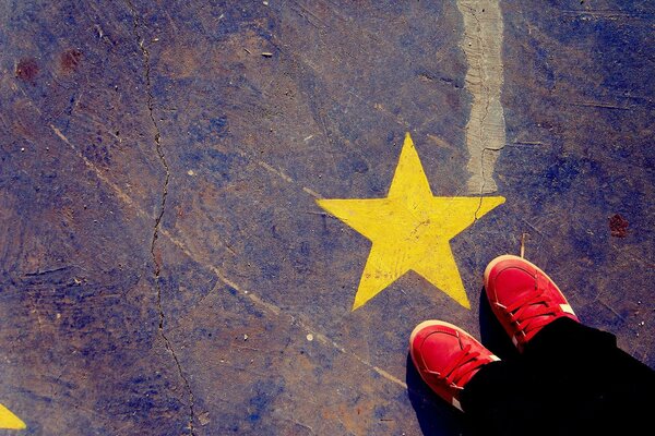 Texture. Red sneakers and a star. Drawing on asphalt