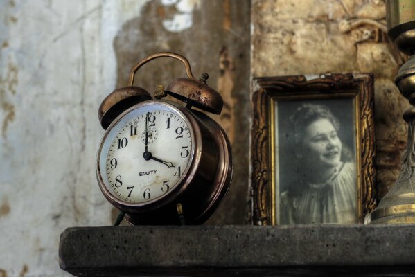 Una vieja foto en blanco y negro junto a un reloj retro