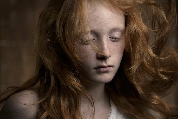 Red-haired girl with freckles sad