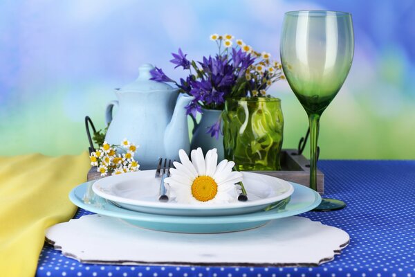 The service consists of plates, forks, a glass and a teapot, and giving a summer mood - daisies and cornflowers