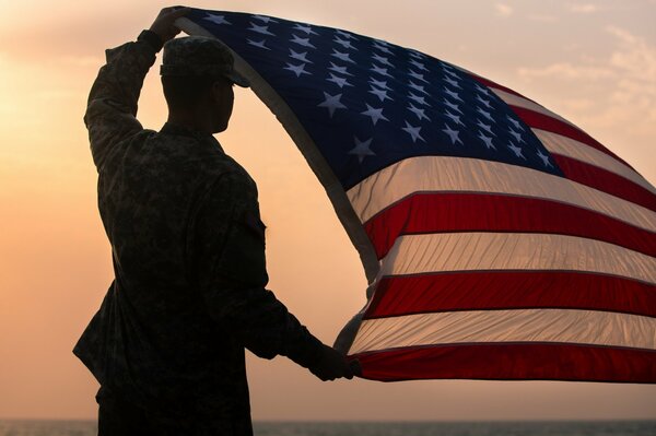 A US Army soldier folds a flag