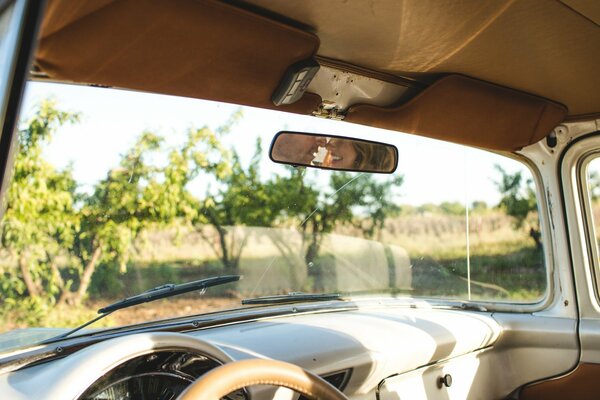 Auto retrò con vista sul paesaggio e riflessione della coppia nello specchio