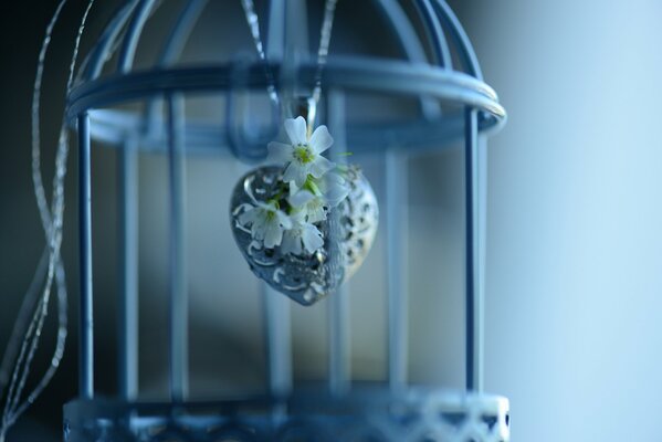 Heart-shaped pendant with a flower in a cage