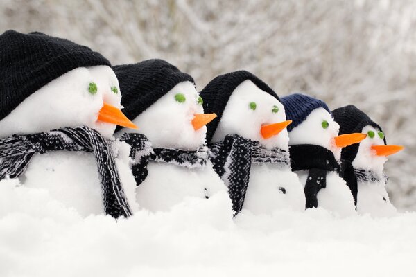 5 bonhommes de neige dans des chapeaux et des écharpes en tricot noir