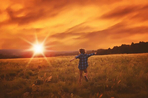 Мальчик бежит по полю в лучах солнца