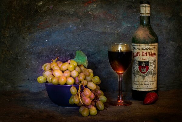 Still life with a bunch of grapes and a bottle of wine