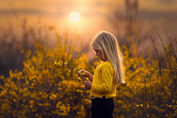 Una niña en el fondo de un campo amarillo