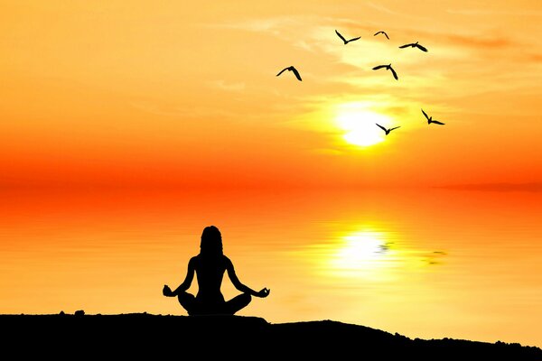 Uomo meditante al sole in riva al mare