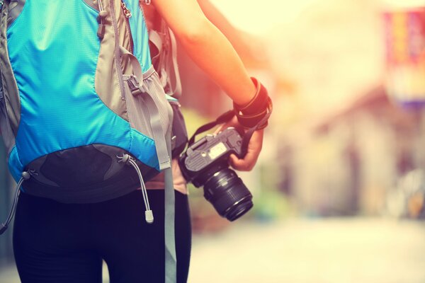 Mädchen mit Rucksack und Kamera in der Hand