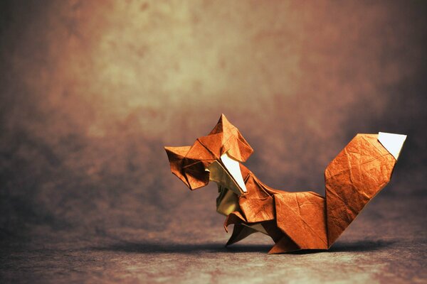 Origami of a red fox with a raised paw