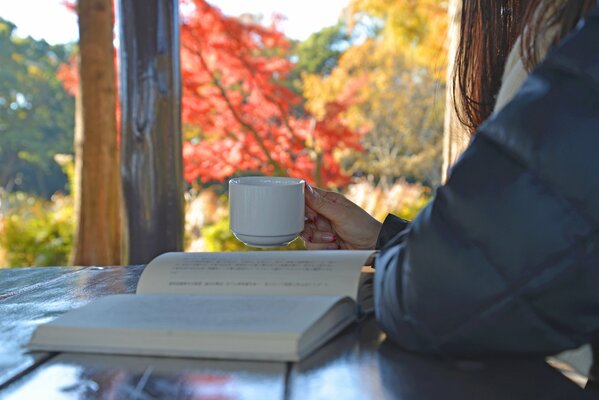 Herbstgetränk mit einem Buch in der Hand