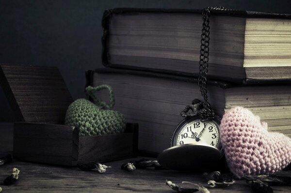 Knitted hearts with books on the floor