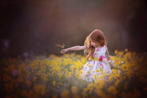 Una niña en un campo de verano floreciente