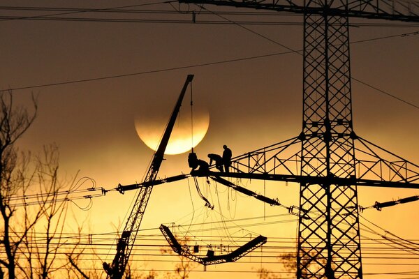 Bild Elektroinstallateure arbeiten bei Sonnenuntergang in der Höhe