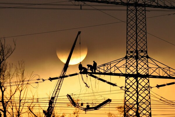 Immagine i elettricisti lavorano in quota al tramonto