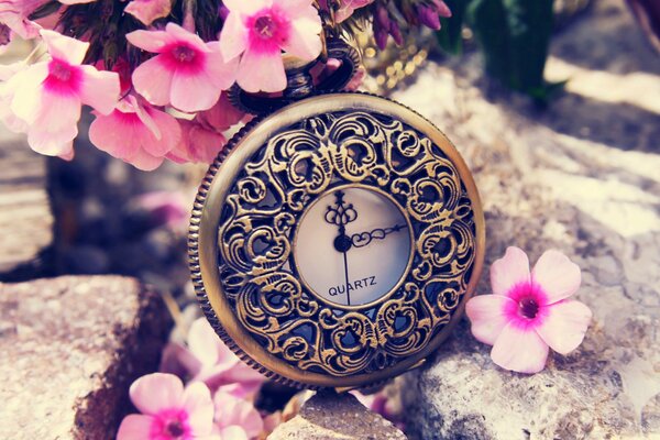 A watch in expensive engraving next to flowers