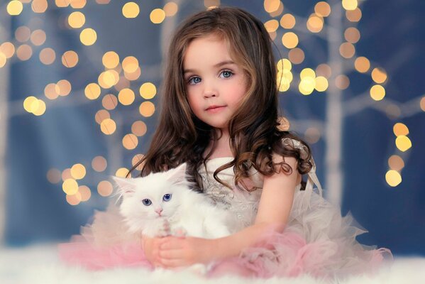 Foto de una niña con un gato blanco