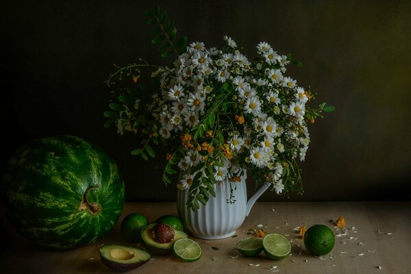 Still life of flowers, watermelon, sliced lime and avocado