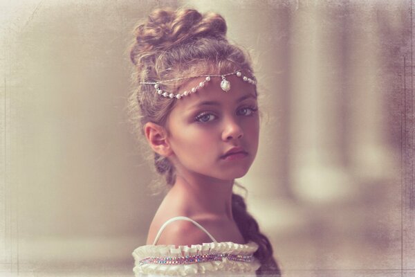 Retrato de una niña con un hermoso peinado y decoración en la cabeza