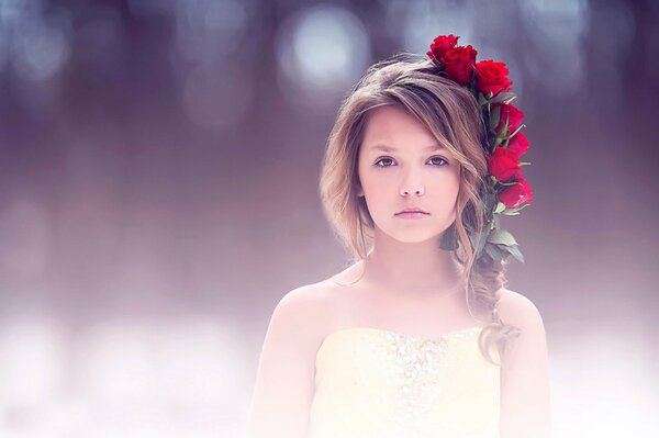 Ragazza con una corona di fiori rossi