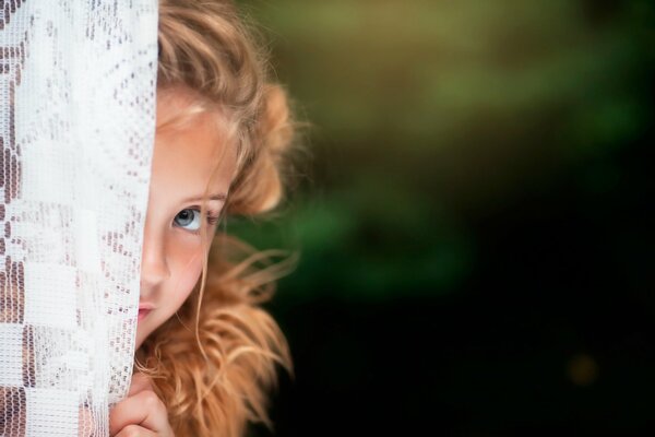 Photo d une fille qui regarde derrière les rideaux