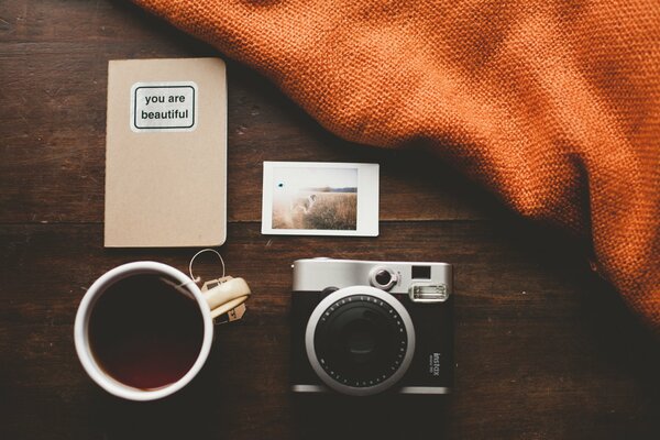 Appareil photo avec une tasse de thé à côté du plaid