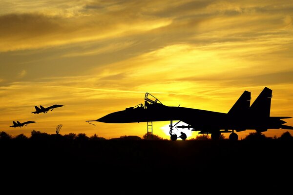 Silhouette eines Militärflugzeugs vor dem Hintergrund eines schönen Sonnenuntergangs