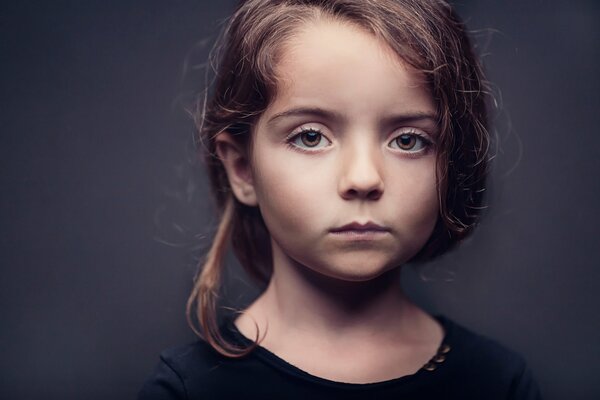 Portrait of a brown-eyed girl on a dark background