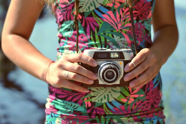 Vecchia macchina fotografica con cinturino in mano ragazza