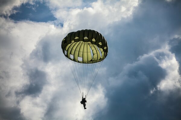 Ein Fallschirmspringer macht einen Sprung. Blauer Himmel in den Wolken