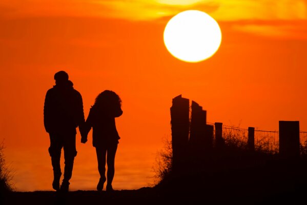 Das Paar geht in einen schönen Sonnenuntergang