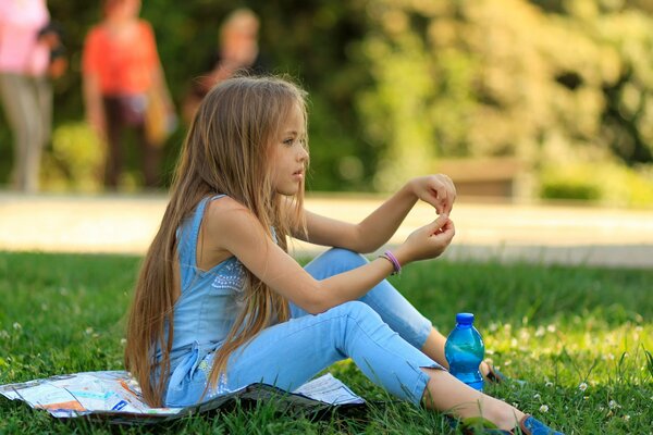 Jeune modèle avec de beaux cheveux posant sur l herbe