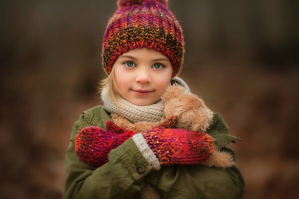 Portrait of a girl with a teddy bear on a blurry background