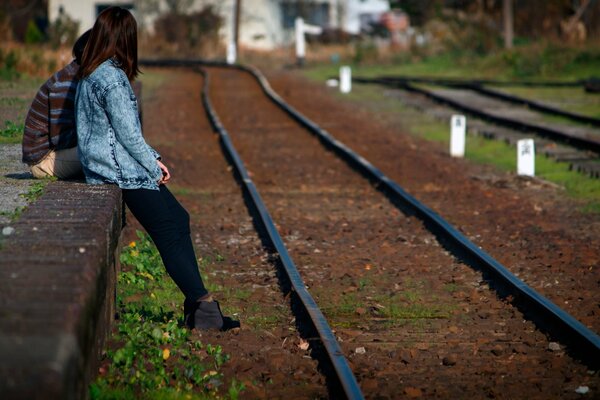 The girl is standing next to the rails