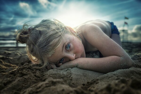 Chica con ojos azules en la playa de arena