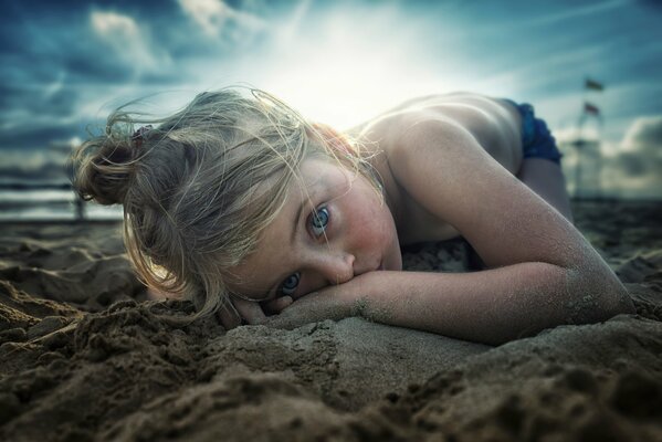 Ragazza con gli occhi blu sulla spiaggia di sabbia