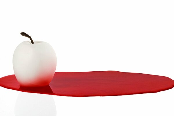 White apple on a red spot on a light background