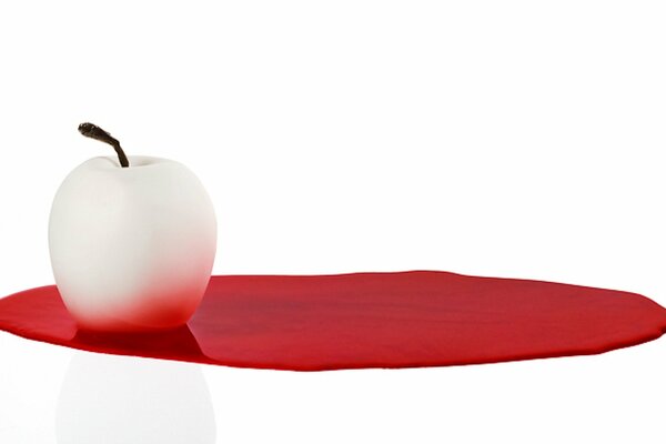 Pomme blanche sur une tache rouge sur fond clair