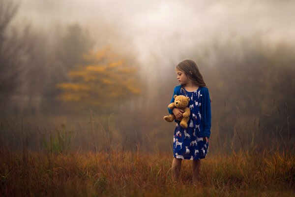 A girl with a bear cub in a foggy forest