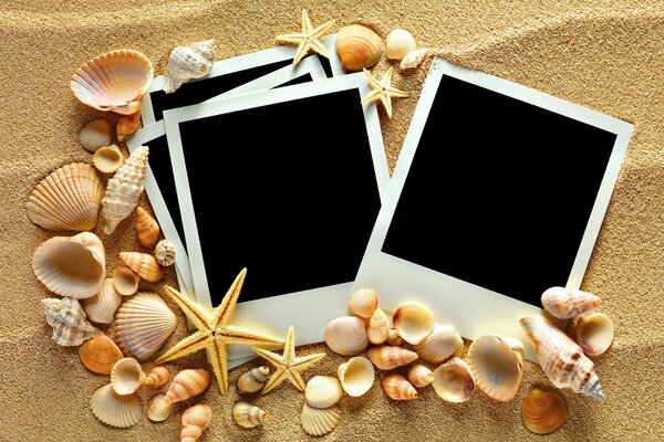 Image of black photo frames on the background of sea sand and shells