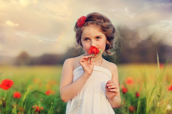 Niña en un campo de amapola