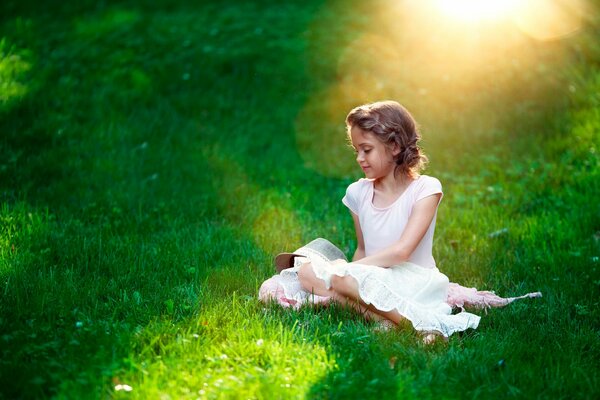 Ragazza in abito bianco su una radura verde