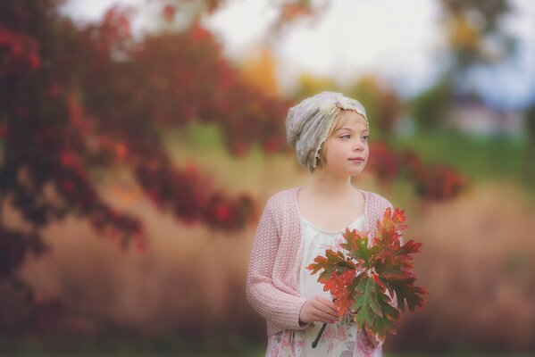 A girl in autumn with a herbarium in her hands